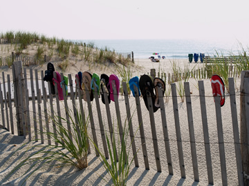 Flip Flops along the barrier fencing at the beach entrance.